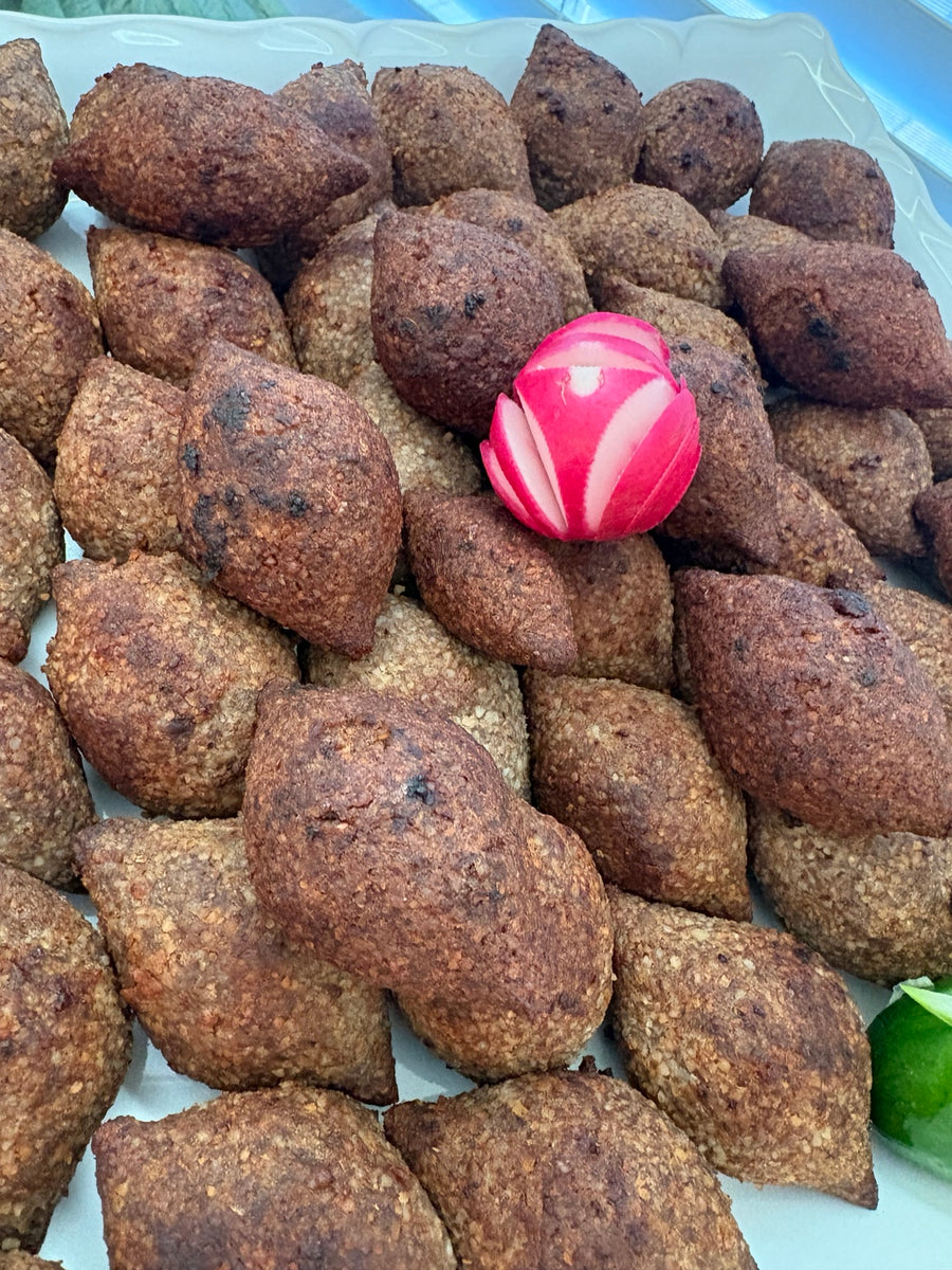 Kibbeh arranged on a Mama Love catering platter